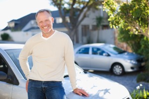 Mature man standing next to car 